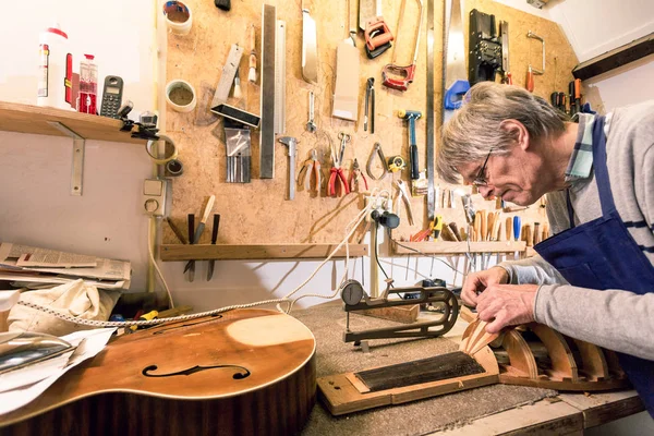 Luthier concentrandosi sulla scultura di un liuto — Foto Stock