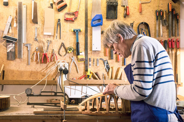 Luthier working at his lute on the workbench