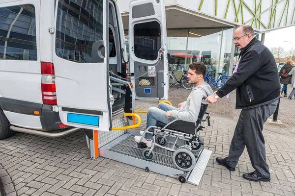 Conductor que asiste al pasajero en silla de ruedas — Foto de Stock