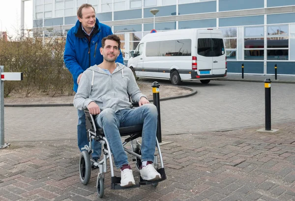 Vater schubst Sohn im Rollstuhl — Stockfoto