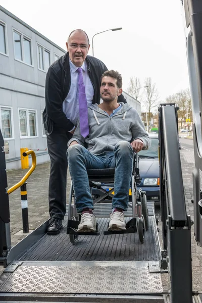 Fahrer hilft Mann im Rollstuhl — Stockfoto
