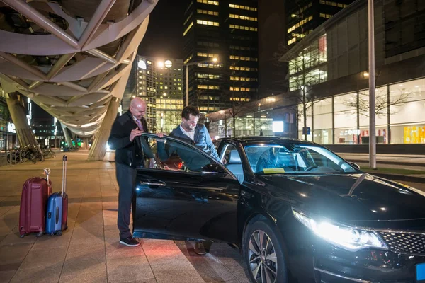 Professional driver assisting passenger — Stock Photo, Image