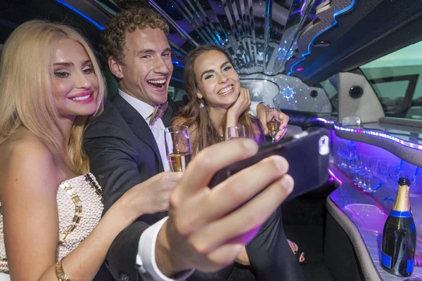 Vänner tar en selfie i en limousine — Stockfoto