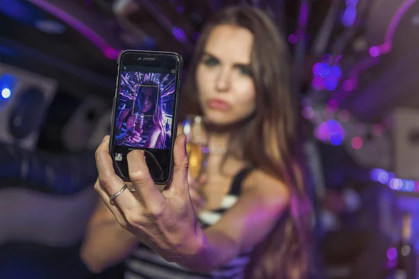 Jovem fêmea tomando uma selfie em uma limusine — Fotografia de Stock