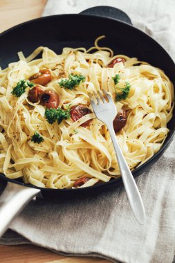 Bir dökme demir tavada lezzetli tagliatelle makarna