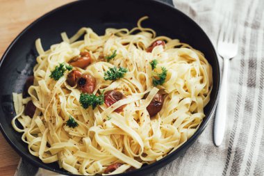 Bir dökme demir tavada lezzetli tagliatelle makarna