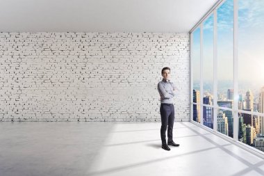 Büyük pencereler ile parlak bir temiz oda ayakta iş adamı