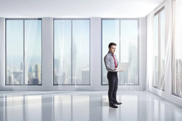 Hombre de negocios de pie en una habitación limpia y luminosa con grandes ventanas —  Fotos de Stock