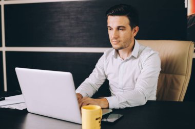 Çekici adam akıllı rahat kıyafet Office çalışma evinde oturan