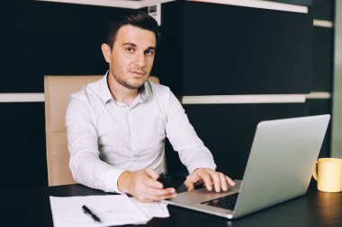 Çekici adam akıllı rahat kıyafet Office çalışma evinde oturan