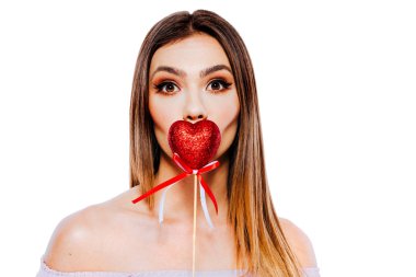 Güzel genç bir kadın model, elinde kırmızı bir kalp madalyası var.