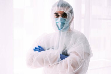 Erkek doktor ya da bilim adamı koruyucu giysi ve yüz maskesi giyiyor. 