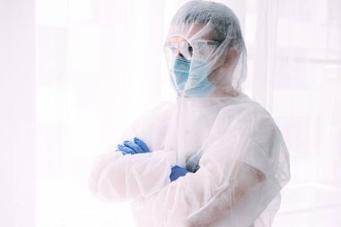 Erkek doktor ya da bilim adamı koruyucu giysi ve yüz maskesi giyiyor. 