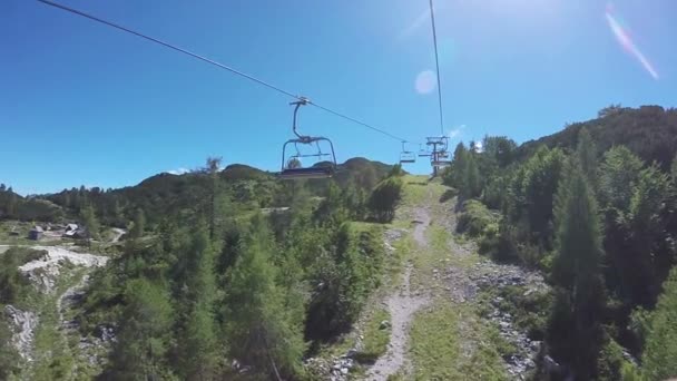 Chairlift cable hoist ride on bright summer day — Stock Video