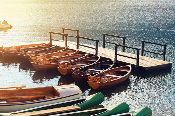 Small wooden boats and canoes tied to empty pier — Stock Photo, Image