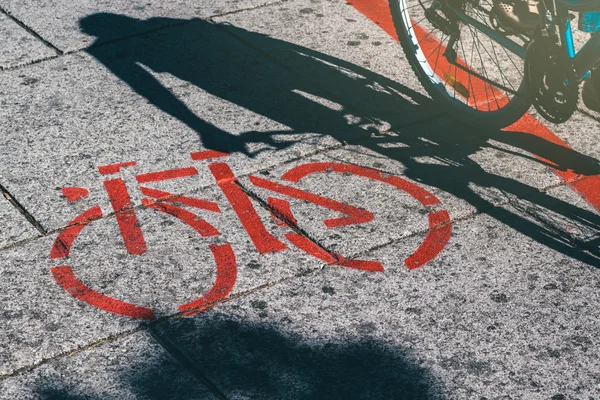 Schaduw van de vrouwelijke fietser en fiets route wegmarkering — Stockfoto