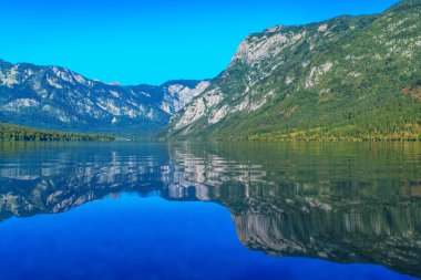 Julian Alps yüzeyinde yansıtan ile Bohinj Gölü