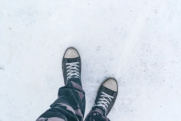 Beyaz asfalt yolda giyilen gri spor ayakkabı Üstten Görünüm — Stok fotoğraf