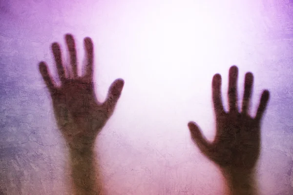 Persona atrapada, silueta trasera iluminada de manos detrás de vidrio mate —  Fotos de Stock