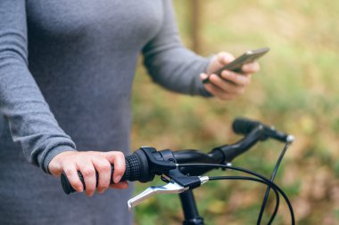 Cep telefonunuzun ve açık havada Bisiklet kadınla