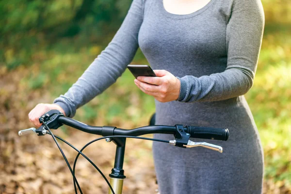 Cep telefonu açık havada üzerinde bisiklet manifatura kadınla