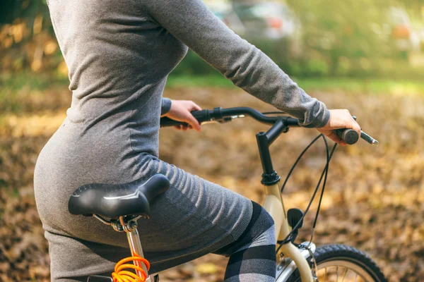 Mulher sexy posa com sua bicicleta no parque durante o outono — Fotografia de Stock