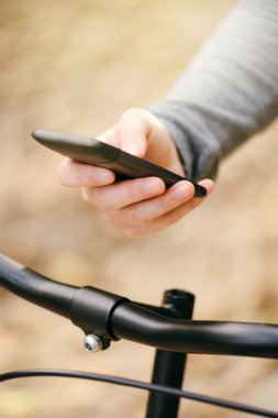Kadın manifatura bisiklet sürme sırasında telefon