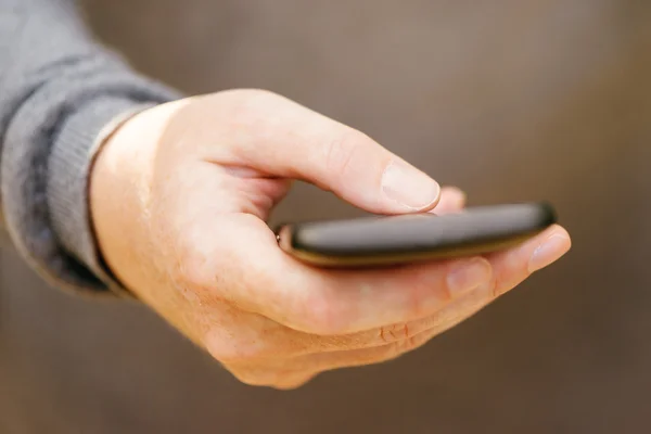 Primer plano de la mano femenina con smartphone móvil — Foto de Stock