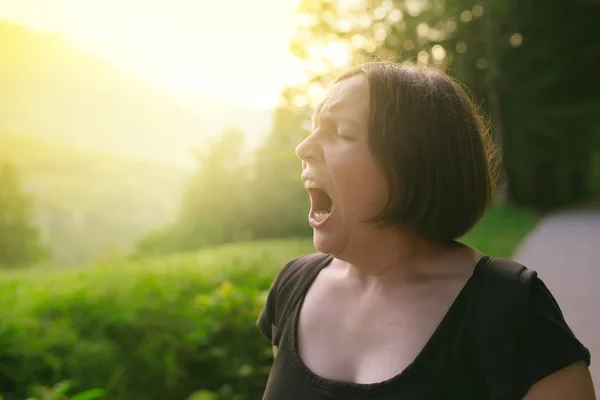 Jovem mulher adulta bocejando ao ar livre pela manhã — Fotografia de Stock