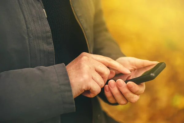 Női kéz mobiltelefon szabadban közelről — Stock Fotó