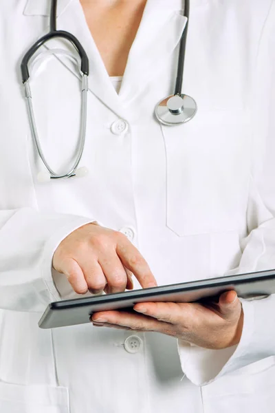 Médico geral feminino usando computador tablet — Fotografia de Stock