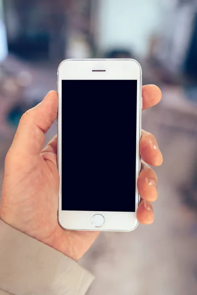 Main masculine tenant smartphone blanc avec écran blanc — Photo