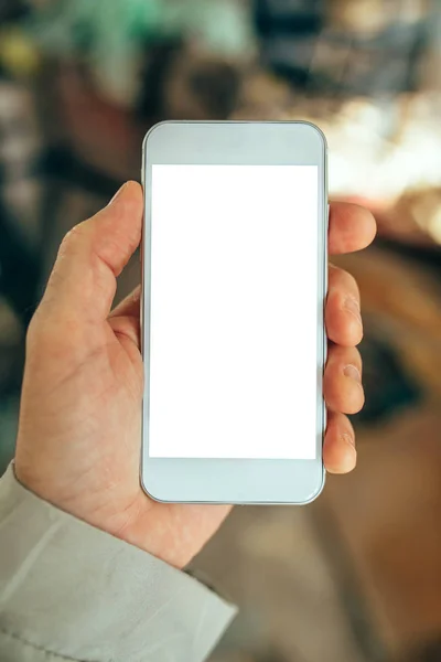 Mão masculina segurando smartphone branco com tela em branco — Fotografia de Stock