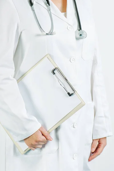 Kvinnliga läkare poserar med Urklipp anteckningar och blankt papper — Stockfoto