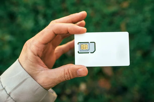 Αρσενική χέρι κρατά κάρτα Sim κινητού τηλεφώνου — Φωτογραφία Αρχείου
