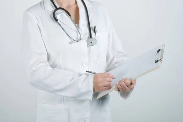 Medico donna che scrive sugli appunti blocco note carta bianca — Foto Stock