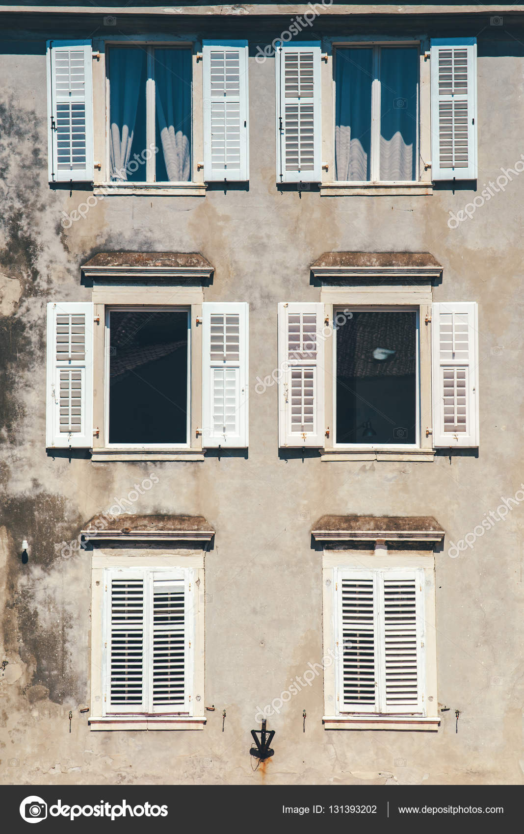 Hausfassade und alte Fenster mit klassischen Holzfenstern