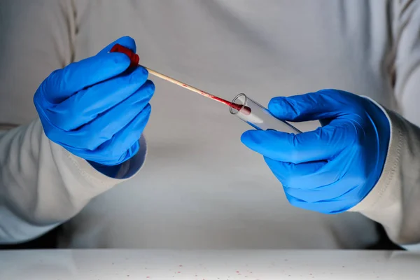 Técnico forense recolhendo amostra de DNA da mancha de sangue — Fotografia de Stock