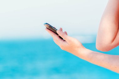 Eller manifatura iletide sahil üstünde hareket eden telefon