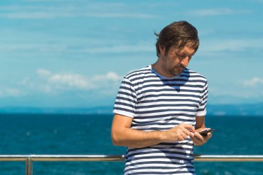 Deniz kenarında Sms gönderme soyulmuş denizci tişörtlü adam