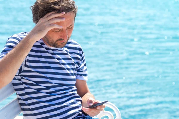 Mobil Sms mesajý okuma çizgili denizci tişörtlü endişeli adam