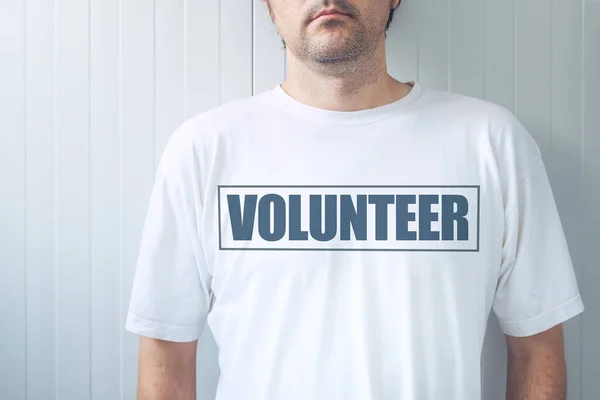 Cara vestindo camisa com etiqueta Voluntária impressa no peito — Fotografia de Stock