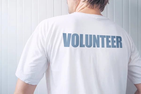 자원 봉사자 라벨 뒷면에 인쇄 된 셔츠를 입고 남자 — 스톡 사진