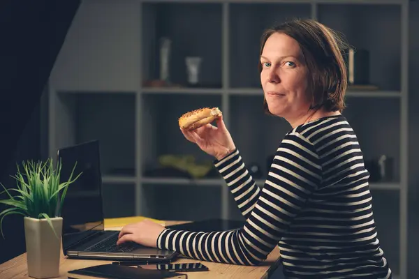 Žena jíst sezamových housku v úřadu — Stock fotografie