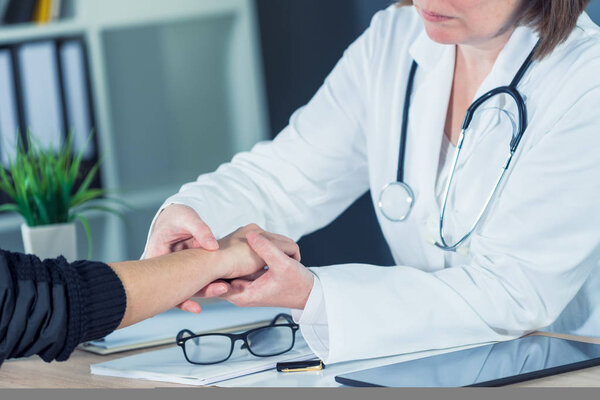 Female patient at orthopedic doctor medical exam for wrist injur