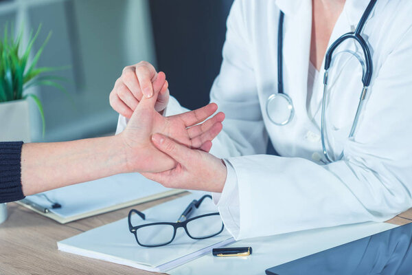 Female patient at orthopedic doctor medical exam for wrist injur