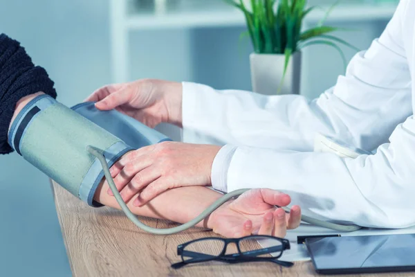 Médico cardiólogo midiendo la presión arterial del paciente femenino — Foto de Stock