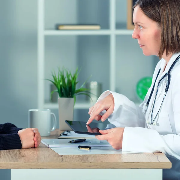 Médecin femme présentant les résultats de l'examen médical au patient en utilisant t — Photo