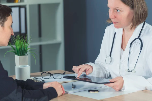 Paciente do sexo feminino consultada pelo médico em consultório hospitalar — Fotografia de Stock