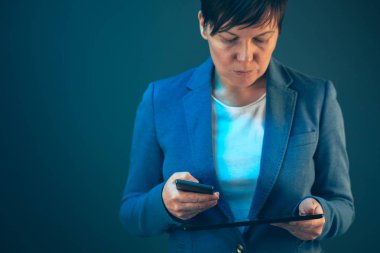 Cep telefonu ve tablet bilgisayar kullanarak iş kadını